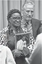  ?? JACK GRUBER/USA TODAY ?? Jon Stewart and Anesta Maria St. Rose Henry, holding a portrait of her husband, Candidus, at the congressio­nal hearing last Tuesday.