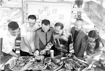  ??  ?? Henry (second left) and Oliver (left) together with the other invited guests trying out some of the traditiona­l delicacies offered at the festival.