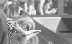  ?? CHRIS PEDOTA AFP/ GETTY IMAGES ?? Mija Quigley of Princeton Junction, N. J., embraces the name of her son Patrick Quigley at the World Trade Center in New York. Her son died aboard Flight 175 on Sept. 11, 2001.