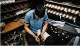  ??  ?? An employee of Grishko company produces pointe shoes in the company’s Moscow workshop.