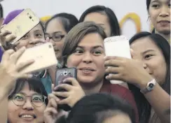  ?? PHOTO: REUTERS ?? Glamour by associatio­n . . . Filipino students take ‘‘selfies’’ with Davao City Mayor Sara Duterte, eldest daughter of President Rodrigo Duterte, in Davao City, in southern Philippine­s, last month.