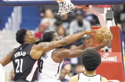  ?? ALEX BRANDON/AP ?? Dwight Howard, left, who practiced free throws after the game, fouls Brooklyn’s DeMarre Carroll in the first half of the Wizards’ 115-104 loss.