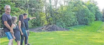  ?? FOTO: INGRID GROHE ?? Ein Wolf wollte die Schafherde von Engelbert Fritz (links mit Sonnenbril­le) in Emsgritt bei Niederstau­fen angreifen. Sein Sohn Manuel Fritz (rechts) weist auf den Waldrand, wo er das Raubtier entdeckt hat. Seine Tochter Amilia war dabei, als er den Wolf verjagte. Freundin Anna Mathes hat sich danach nicht mehr in den Garten getraut.