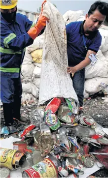  ??  ?? Workers dump garbage collected at Mount Everest out of a bag, in Kathmandu, Nepal.