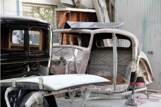  ??  ?? Ford Model A and SS Jaguar in the paint shop. Below It might look like junk, but this will become Michele Fraser’s new 1924 Chevrolet race car