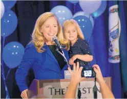  ?? DEAN HOFFMEYER/ RICHMOND TIMES-DISPATCH ?? Democrat Abigail Spanberger claims victory in the 7th District Virginia congressio­nal race while holding her daughter Catherine, 4, during a victory party in Richmond, Va., late Nov. 6. She defeated two-term Republican congressma­n Dave Brat.