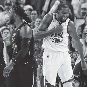  ?? THE ASSOCIATED PRESS ?? Golden State Warriors forward Kevin Durant, right, reacts after blocking a shot by Cleveland’s LeBron James (not shown) during the second half of Monday’s game in Oakland, Calif.