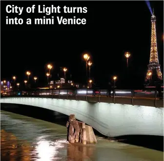  ??  ?? HIGH TIDE: Water rushes past Alma bridge by the Zouave statue which is used as a measuring instrument during floods in Paris. PHOTO: CHRISTOPHE ENA