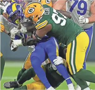  ?? MIKE DE SISTI / MILWAUKEE JOURNAL SENTINEL ?? Packers nose tackle Kenny Clark stuffs Rams running back Darrell Henderson near the line of scrimmage during Week 12.