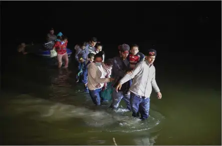  ?? DARIO LOPEZ-MILLS — THE ASSOCIATED PRESS ?? Migrant families, mostly from Central American countries, wade through shallow waters after being delivered by smugglers on small inflatable rafts on U.S. soil in Roma, Texas, on Wednesday.