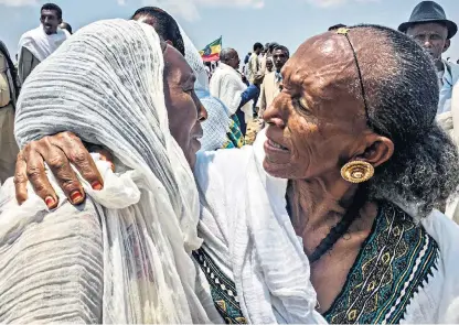  ??  ?? At a ceremony to mark the reopening of two border crossings for the first time in 20 years, an Ethiopian mother greets her daughter from Eritrea, left; and below, Ethiopian women wait for Eritrean relatives