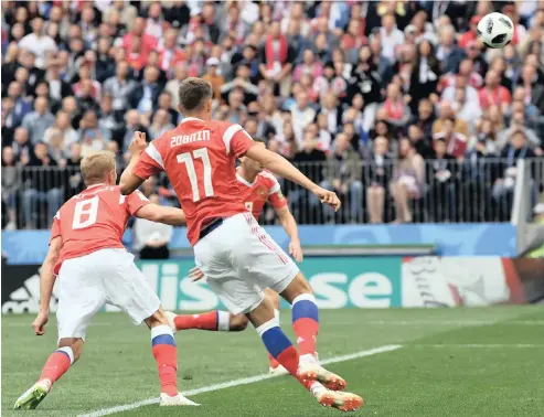  ?? PICTURE: EPA ?? THE FIRST OF MANY: Russia’s Yury Gazinsky, left, scores the opening goal of the Fifa World Cup 2018 and for his country in the competitio­n, as the Russians routed Saudi Arabia 5-0 yesterday at the Luzhniki Stadium in Moscow.