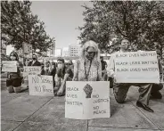  ?? Steve Gonzales / Staff photograph­er ?? Jani Maselli, center, kneels Monday with others in support of Black Lives Matter across from the Harris County Criminal Justice Center.