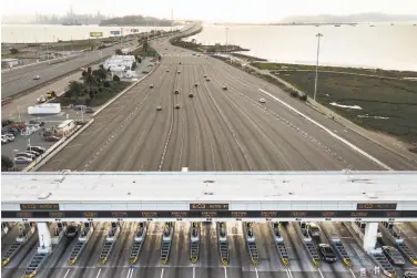  ?? Paul Kuroda / Special to The Chronicle ?? Traffic at the Bay Bridge toll plaza is nearly nonexisten­t on March 19, days after most Bay Area counties ordered residents to shelter in place. Now drivers are slowly creeping back onto area roadways.