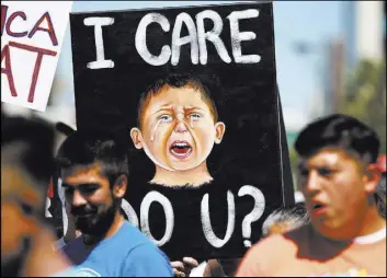  ??  ?? A painting by Baily Ludwick is held Saturday at the Las Vegas immigratio­n rally.