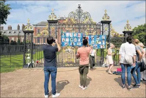  ?? ISABEL INFANTES/THE ASSOCIATED PRESS ?? People look at messages and flowers attached to the Golden Gates of Kensington Palace in London, ahead of the 20th anniversar­y of Princess Diana’s death. The way Princess Diana died in a high-speed Paris car crash — while she and her boyfriend were...