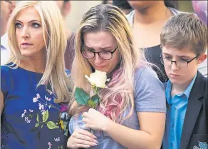  ?? JON SUPER / REUTERS ?? A young woman holds a rose while looking at the messages and floral tributes left for the victims of the attack on Manchester Arena, in Manchester, on Wednesday.