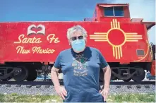  ?? EDDIE MOORE/JOURNAL ?? Rick Martinez, member at large with Keep Santa Fe Beautiful, added heart hands to the red caboose at the Railyard.