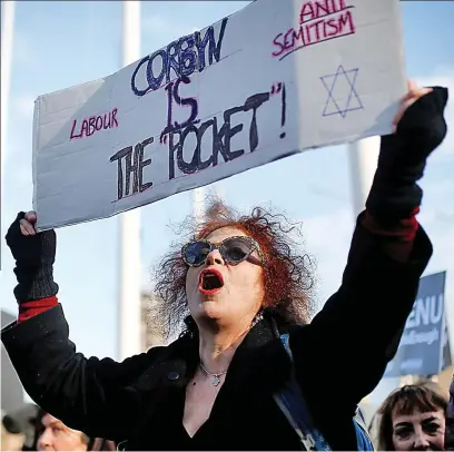  ??  ?? Pointed: A placard refers to Jeremy Corbyn’s claim that Labour has ‘pockets’ of anti-Semitism