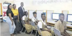  ?? ?? From left: Dana Coley, senior associate, advisory at PWC Jamaica; Natalie Fearon, manager, marketing and communicat­ions at PWC Jamaica; and Father Carl F Clarke, principal at Holy Trinity High School join students of the Academic Interventi­on Programme (AIP) in proudly displaying four of the eight newly donated desktop computers.