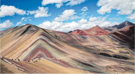 ?? FOTOS: DPA ?? Ein Berg der besonderen Art: Noch ist der Rainbow Mountain ein unbekannte­s Reiseziel in Peru – doch er hat das Potenzial, ganz groß rauszukomm­en.