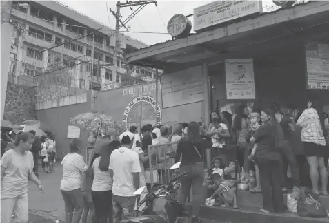  ?? PAUL JUN E. ROSAROSO ?? Visitors at the Cebu City Jail line up at the gate under the scorching heat of the sun while waiting to be allowed to get inside the facility.