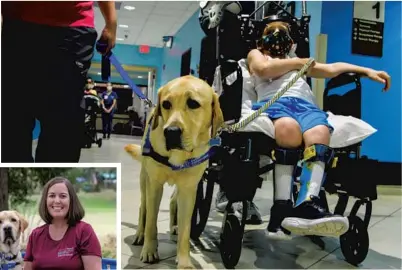  ?? ?? Parks goes for a walk with a patient at Orlando Health Arnold Palmer Hospital for Children.