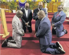  ?? ?? Pastor Levi Johnson (third left), board member and executive secretary of the Jamaica Union Conference of Seventh-day Adventists (JAMU), offers the prayer of dedication to install Donmayne Gyles (centre foreground) as the new president and CEO of Andrew Memorial Hospital on Saturday, May 13, 2023 at Andrews Memorial Seventh-day Adventist Church in St Andrew. With them are Pastor Adlai Blythe (left), board member treasurer of JAMU; Pastor Everett Brown (second left), board chairman and president of JAMU; and Dr Frank Geneus, health ministries director, Inter-american Division of Seventh-day Adventists.