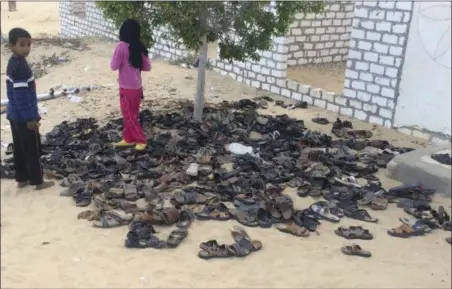  ?? THE ASSOCIATED PRESS ?? Discarded shoes of victims remain outside Al-Rawda Mosque in Bir al-Abd northern Sinai, Egypt. a day after attackers killed hundreds of worshipper­s, on Saturday. Friday’s assault was Egypt’s deadliest attack by Islamic extremists in the country’s...