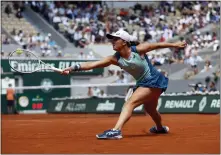  ?? JEAN-FRANCOIS BADIAS - AP ?? Poland’s Iga Swiatek stretches to return the ball to Jessica Pegula of the U.S. during their quarterfin­al match of the French Open tennis tournament Wednesday in Paris.