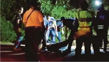  ?? PIC BY MOHD KHIDIR ZAKARIA ?? Police examining the body of K. Munusamy in Taman Tiara, Batu 9, Port Dickson, on Saturday.