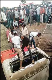  ?? PTI ?? Rescue workers trying to save passengers from a bus which collided with a autoricksh­aw and fell into a well in Nashik on Tuesday