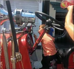  ??  ?? Hunter Ferrante, 3, of New Jersey rings the bell on a fire truck at the Antique Fire Engine Muster and Show. He is the son of Laura and Jonathan Ferrante.