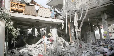  ?? — Reuters ?? A Palestinia­n inspects the site of an Israeli strike on a house in Rafah on Thursday.