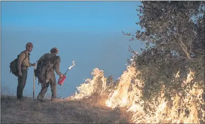  ?? NIC COURY — THE ASSOCIATED PRESS, FILE ?? Firefighte­rs light a controlled burn along Nacimiento­Fergusson Road to help contain the Dolan Fire near Big Sur on Sept. 11, 2020.