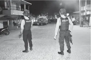  ?? Reuters photo ?? Armed police officers stand as they guard an area following an explosion after they arrested a suspected terrorist in Sibolga, North Sumatra province, Indonesia. —