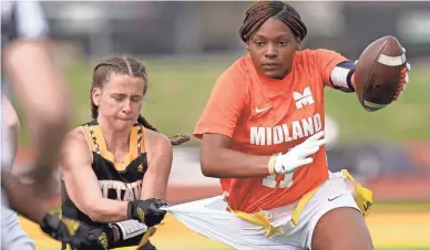  ?? ORLIN WAGNER/AP ?? Ottawa defensive end Jennifer Anthony, left, tackles Midland's JaNasia Spand (11) during an NAIA flag football game in Ottawa, Kan.