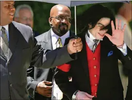  ?? CONNIE ARAMAKI/GETTY IMAGES ?? U.S. pop star Michael Jackson gestures to his fans as he leaves the Santa Barbara County Superior Court in 2005 in Santa Maria, Calif.