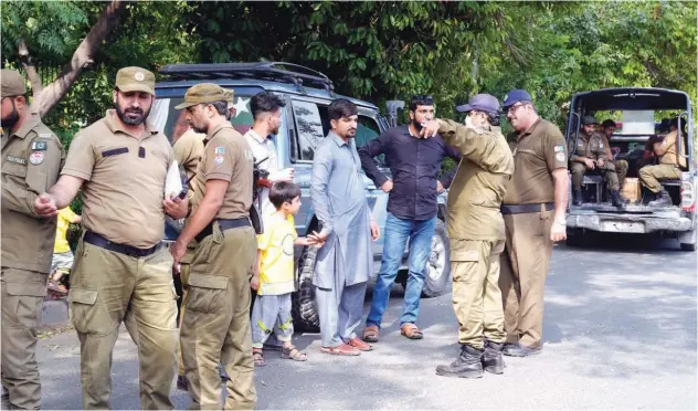  ?? Associated Press ?? ↑
Police officers search a man at a temporary checkpoint around the home of Imran Khan in Lahore on Wednesday.