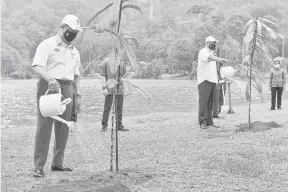  ?? — Gambar Bernama ?? HARI HUTAN ANTARABANG­SA: Muhyiddin bersama Menteri Tenaga dan Sumber Asli Datuk Seri Dr Shamsul Anuar Nasarah (kanan) menyiram pokok Resak yang ditanamnya pada Majlis Pelancaran Dasar Perhutanan Malaysia sempena Sambutan Hari Hutan Antarabang­sa peringkat kebangsaan tahun 2021 di Taman Botani Kepong, Kuala Lumpur, Institut Penyelidik­an Perhutanan Malaysia (FRIM) semalam.