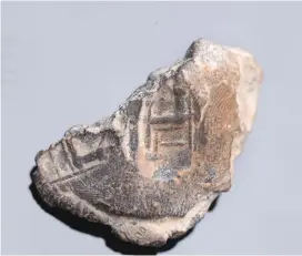  ?? (Eliyahu Yanai/City of David Archives) ?? A SEAL featuring a man, perhaps a king, sitting on a big chair before pillars.