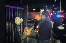  ??  ?? DINO GRANIELLO, left, and Jessie Xenakis light candles near the artist collective that hosted the show. The venue is known to locals as the Oakland Ghost Ship.