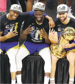  ?? MICHAEL DWYER AP ?? Warriors players Andre Igoudala, Draymond Green and Klay Thompson pose for photos with the Larry O’Brien Trophy after defeating Boston in Game 6 of the NBA Finals.