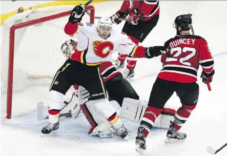  ?? JULIO CORTEZ/ THE ASSOCIATED PRESS ?? Flames centre Matt Stajan celebrates after scoring a goal on New Jersey Devils goalie Cory Schneider during the third period of Friday’s game, in Newark, N.J. Stajan’s goal tied the game 3-3 and the Flames went on to win in overtime.