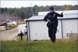  ?? ROBERT F. BUKATY — THE ASSOCIATED PRESS FILE ?? A police officer gives an order to the public during a manhunt at a farm in Lisbon, Maine, on Oct. 27followin­g two mass shootings.