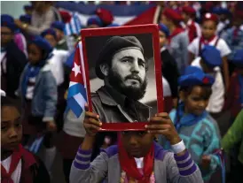  ?? Bild: RAMON ESPINOSA ?? EL COMANDANTE. En flicka håller upp en bild av Fidel Castro under en minneshögt­id i Havanna i början av januari.