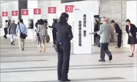  ?? KAZUHIRO NOGI/AFP ?? Shareholde­rs arrive at Japan’s Toshiba Corp for the annual meeting in Chiba, Chiba prefecture yesterday.