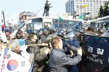  ??  ?? Protesters supporting Park clash with riot policemen near the Constituti­onal Court in Seoul, South Korea. — Reuters photos