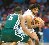  ?? JARED C. TILTON/GETTY ?? North Carolina guard RJ Davis handles the ball against Michigan State guard Tre Holloman during a second-round NCAA Tournament game Saturday in Charlotte, North Carolina.