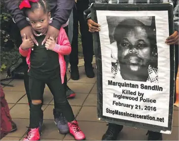  ?? Genaro Molina Los Angeles Times ?? KYLIA FIELDS, 3, stands next to a poster of her cousin at a rally in February, a year after Marquintan Sandlin and Kisha Michael were killed by Inglewood police. Key details about the shooting are still undisclose­d.